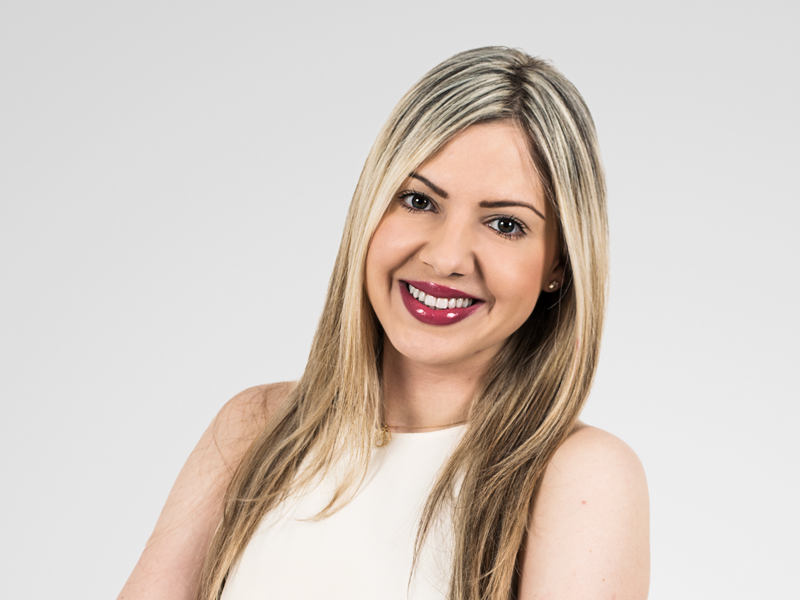 Andrea Moundi Savvides Harneys front portrait image on a grey background